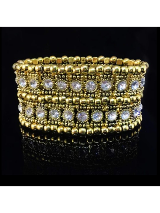 Bracelet élastique serti de pierres cristal, perles et matériaux dorés.